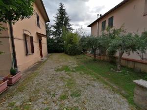 ein leerer Hof neben einem Gebäude mit Bäumen in der Unterkunft La Musa - Appartamento Clio in Spello