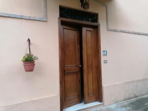 a wooden door on the side of a building with a potted plant at La Musa - Appartamento Clio in Spello