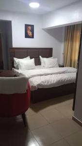 1 dormitorio con 1 cama grande y 1 silla en House 11 en Ibadán