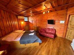 1 dormitorio con 1 cama y 1 sofá en una cabaña en Penzion Ten, en Pardubice
