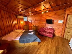 a bedroom with a bed and a couch in a cabin at Penzion Ten in Pardubice