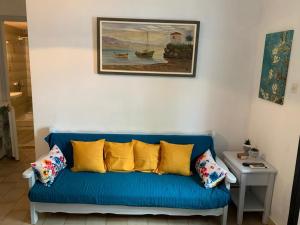 un sofá azul con almohadas amarillas en la sala de estar. en Kastro Studios en Skopelos Town