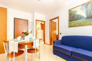 uma sala de estar com uma mesa e um sofá azul em Appartamento Alide Bilo Deluxe - MyHo Casa em Tortoreto Lido