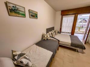 um quarto com 2 camas e uma janela em Golden Riviera No 7 em Lignano Sabbiadoro