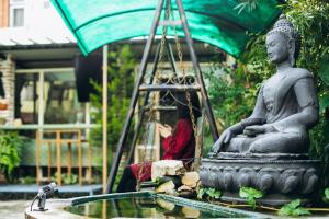 a statue sitting in a fountain in a garden at Omana Hotel in Kathmandu