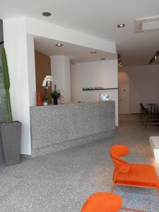 an office with a reception desk and orange chairs at Bianco Hotel in Lakkíon