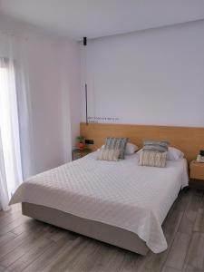 a bedroom with a large white bed with two pillows at Bianco Hotel in Lakkíon