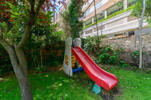a playground with a slide in a yard at For Your Rentals Elegante y cómodo apartamento en Puerta de Hierro SMP41 in Madrid