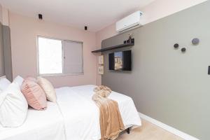 une chambre avec un lit blanc et une fenêtre dans l'établissement Vossa Bossa Consolação, à São Paulo