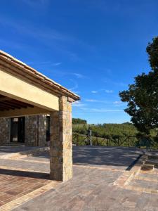 un pabellón de piedra con un cielo azul y árboles en Agriturismo Botri dei Lumachi, 