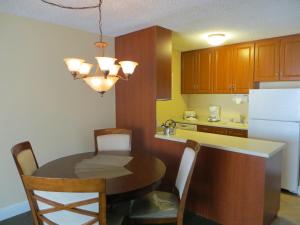 cocina con mesa y cocina con nevera en Jockey Resort Suites Center Strip, en Las Vegas