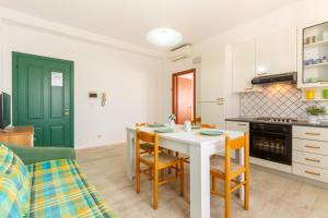 - une cuisine et une salle à manger avec une table et des chaises dans l'établissement Appartamento Alide Bilo 2P - MyHo Casa, à Tortoreto Lido