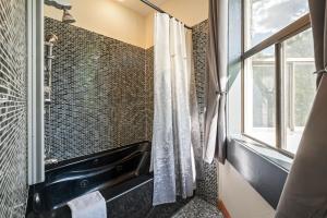un bagno con doccia, lavandino e finestra di Hotel Leavenworth a Leavenworth