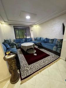 un soggiorno con un divano blu e un tavolo di Appartement vue sur mer sidi Rahal a Sidi Rahal