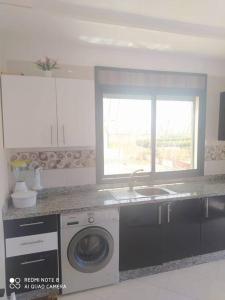 una cucina con lavatrice e finestra di Appartement vue sur mer sidi Rahal a Sidi Rahal