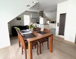 eine Küche und ein Esszimmer mit einem Holztisch und Stühlen in der Unterkunft Ferienwohnung Savoir Vivre in Kiechlinsbergen