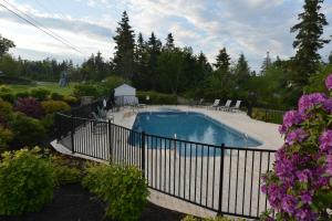 a fence around a swimming pool in a garden at Newagen Seaside Inn in Southport