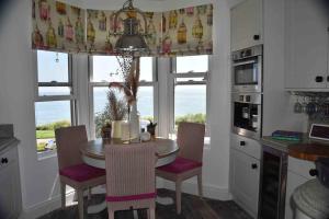 cocina con mesa, sillas y ventana en Amazing sea views and much more…., en Broadstairs