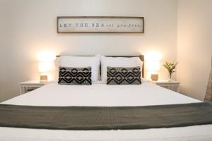a bedroom with a white bed with two tables and two lamps at Clearwater Bohemian Escape - 7 min to the Beach, BBQ Grill, Playground in Clearwater