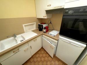 a small kitchen with a sink and a microwave at Tania YourHostHelper in Caen