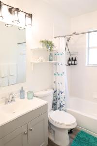 a bathroom with a toilet and a sink and a tub at Clearwater Bohemian Escape - 7 min to the Beach, BBQ Grill, Playground in Clearwater
