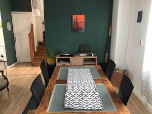 une salle à manger avec une table et un mur vert dans l'établissement ChicEthnik! Maison de ville, 3 chambres, 6 places., à Besançon