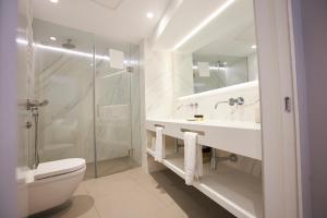 a bathroom with a shower and a toilet and a sink at U-Sense Madrid Santa Ana in Madrid