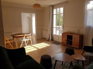 a living room with a couch and a table and chairs at Les Coteaux in Montgeron