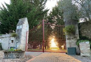 a red gate with a christmas tree on it at Chambres d'Hôtes Les Bournais - Le Clos Milady in L'Ile-Bouchard