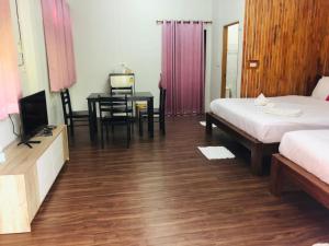 a bedroom with a desk and a bed and a table at กอบสุข รีสอร์ท2 k04 in Ban Ton Liang
