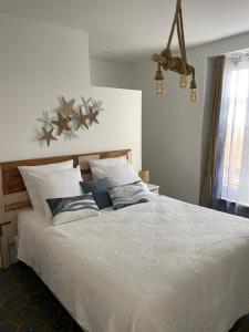 a bedroom with a large white bed with pillows at La Maison du Puits in Cesseras