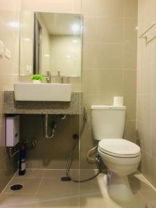 a bathroom with a white toilet and a sink at BGC Uptown 1 BR Condo in Manila