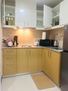 a kitchen with white cabinets and a counter top at BGC Uptown 1 BR Condo in Manila