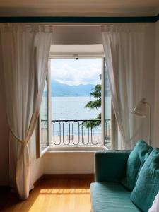 un sofá frente a una ventana con vistas al agua en Miralago Casa Vacanze, en Riva di Solto