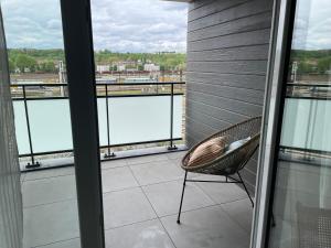 a chair on a balcony with a view of the water at Le Havre de Sérénité - Orly - Gare - Parking privé in Athis-Mons