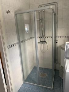 La salle de bains est pourvue d'une douche avec une porte en verre. dans l'établissement Stuga i vassemåla, à Vimmerby