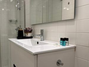 La salle de bains blanche est pourvue d'un lavabo et d'un miroir. dans l'établissement Magalhães Prime, à Porto