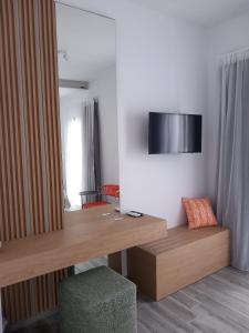 a room with a desk and a television on a wall at Bianco Hotel in Lakkíon +4 photos