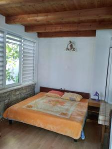 - une chambre avec un grand lit et un plafond en bois dans l'établissement Apartmani Tereza, à Lumbarda