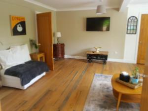 a living room with a bed and a table at The Old House At Home in Castle Combe