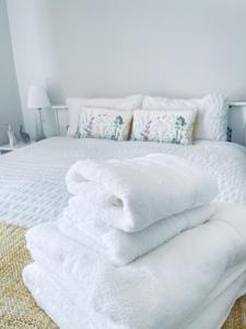 a pile of white towels sitting on top of a bed at Small Doble, Shared House in Bristol
