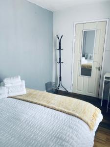a white bedroom with a large bed with white sheets at Small Doble, Shared House in Bristol