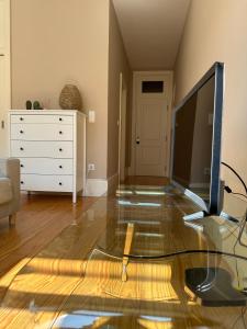 een woonkamer met een televisie op een glazen tafel bij Magalhães Prime in Porto