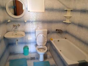 La salle de bains est pourvue de toilettes, d'un lavabo et d'une baignoire. dans l'établissement Apartmani Tereza, à Lumbarda