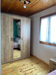 Habitación con puerta con espejo y dormitorio. en Politis' wooden house, en Vasiliki