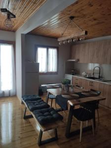 a kitchen with a table and chairs in a room at Politis' wooden house in Vasiliki