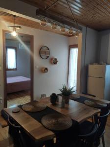 a dining room with a wooden table and chairs at Politis' wooden house in Vasiliki