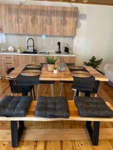 a kitchen with a wooden table with pillows on it at Politis' wooden house in Vasiliki