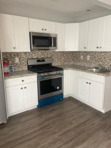 a kitchen with a stove and a microwave at 20 Dupont Beach House in Seaside Heights