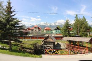 un parque con parque infantil, casas y montañas en Guest House Mengsdorf en Mengusovce